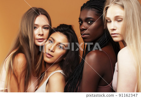 young pretty african and caucasian women posing cheerful together on brown background, lifestyle diverse nationality people concept close up young pretty african and caucasian women posing cheerful together on brown background, lifestyle diverse nationality people concept close up 91162347