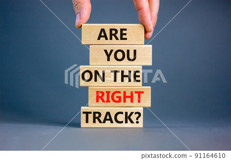 Right track symbol. Concept words Are you on the right track on wooden blocks on a beautiful grey table grey background. Businessman hand. Business motivational and right track concept. Right track symbol. Concept words Are you on the right track on wooden blocks on a beautiful grey table grey background. Businessman hand. Business motivational and right track concept. 91164610
