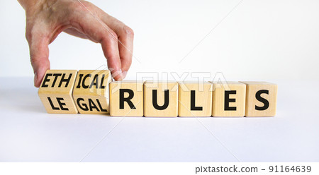 Ethical or legal rules symbol. Businessman turns wooden cubes and changes words ethical rules to legal rules on a beautiful white background. Business and ethical or legal rules concept. Copy space. 91164639
