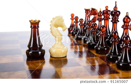 Natural amber different chess pieces figures standing on brown stone board. Close up game concept competition, Classic Gambit Tournament of confrontation. 91165007
