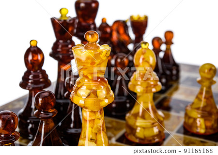 Natural amber different chess pieces figures standing on brown stone board. Close up game concept competition, Classic Gambit Tournament of confrontation. 91165168