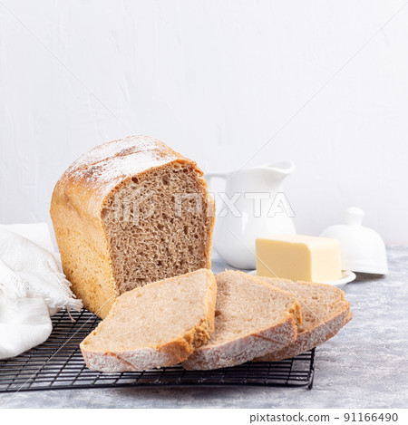 Slices of homemade no knead sandwich bread on cooling rack, square format 91166490