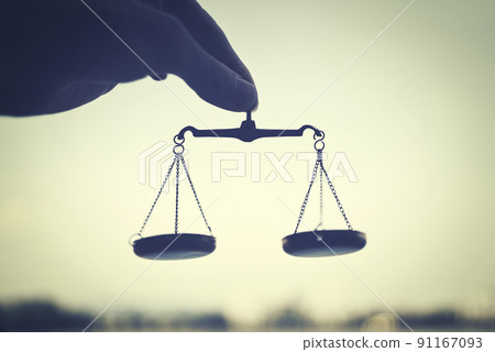 The hand of a man holding a balance and the blue sky 91167093