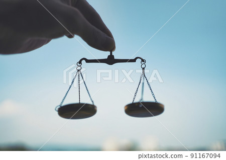 The hand of a man holding a balance and the blue sky 91167094