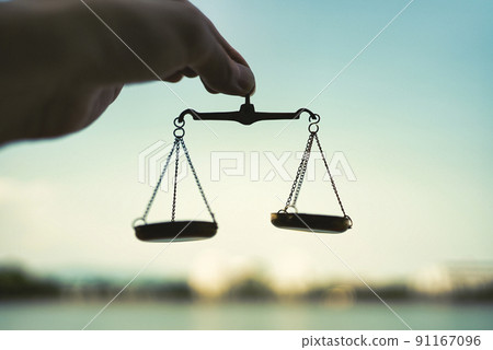 The hand of a man holding a balance and the blue sky 91167096