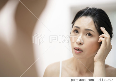 Arafif woman who cares about her hairline while looking in the mirror 91170892