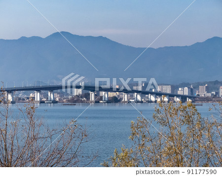 Lake Biwa, Shiga Prefecture, Hira Mountains with early blooming rape blossoms and snow Lake Biwa, Shiga Prefecture, Hira Mountains with early blooming rape blossoms and snow 91177590