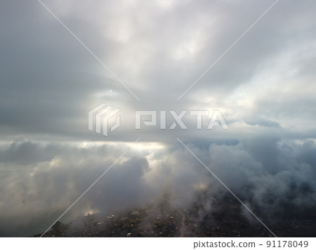 Aerial view. Blue sky sun and fog over calm sea. The drone flies over foggy and fluffy clouds. Abstract aerial nature summer ocean sunset sea and sky background. Vacation, travel and holiday concept. Aerial view. Blue sky sun and fog over calm sea. The drone flies over foggy and fluffy clouds. Abstract aerial nature summer ocean sunset sea and sky background. Vacation, travel and holiday concept. 91178049