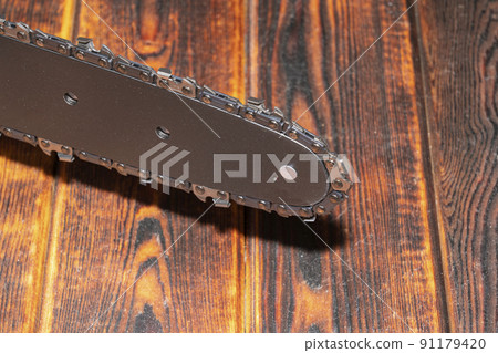 Chain saw on wood on a wood background 91179420