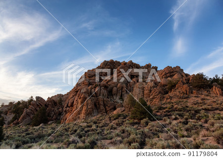 Dry rocky desert mountain landscape with trees. 91179804