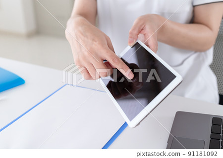 一位在醫院工作的婦女操作並解釋平板電腦 91181092