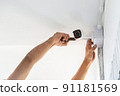 Technicians using a screwdriver to install  the CCTV cameras. 91181569