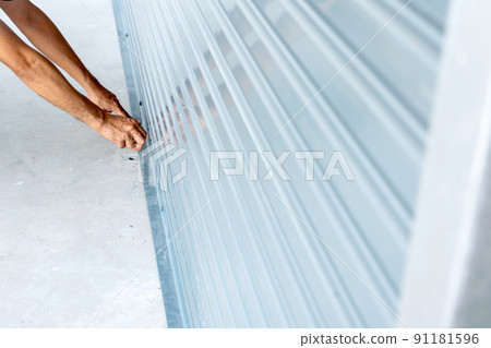 Using a key to open a rolling iron door. 91181596