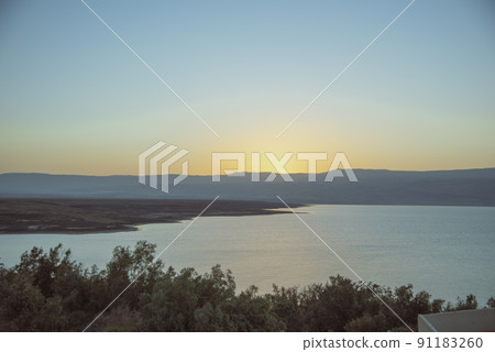 Orange sunrise reflecting off of the Dead Sea. 91183260