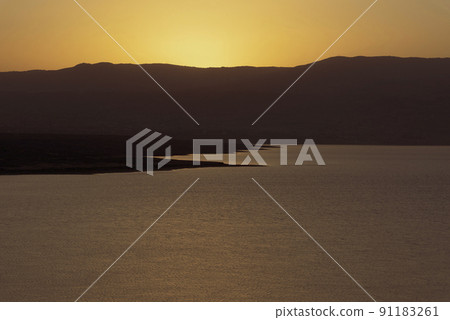 Orange sunrise reflecting off of the Dead Sea. 91183261