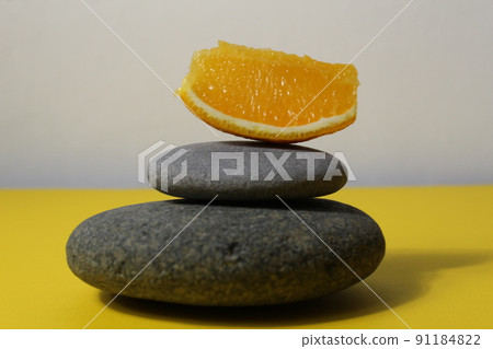 a ballans tower of grey stones and grapefruit orange fruit on a white yellow background with room for text. Benefits of Energy Health Importance Vitamin a ballans tower of grey stones and grapefruit orange fruit on a white yellow background with room for text. Benefits of Energy Health Importance Vitamin 91184822
