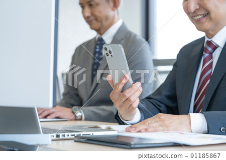 Up the hands of senior men who use smartphones in the office Up the hands of senior men who use smartphones in the office 91185867