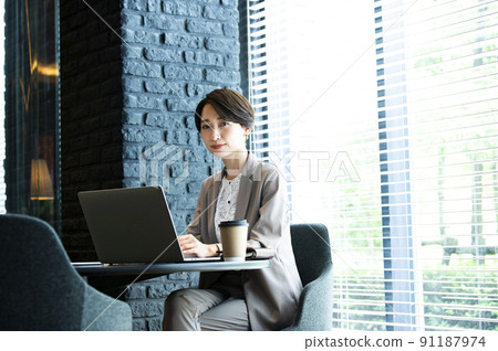 Business women office laptop looking at camera Business women office laptop looking at camera 91187974