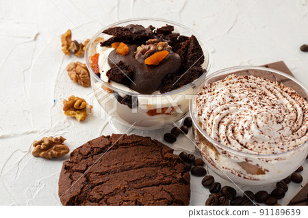 Cocoa mousse dessert in plastic transparent box on grey surface Cocoa mousse dessert in plastic transparent box on grey surface 91189639