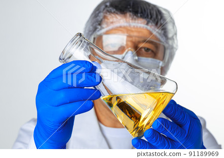 Scientist hands holding some liquid in a glassware in laboratory for analysis 91189969
