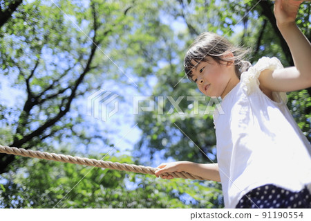 Elementary school girl playing on a tightrope (7 years old) Elementary school girl playing on a tightrope (7 years old) 91190554