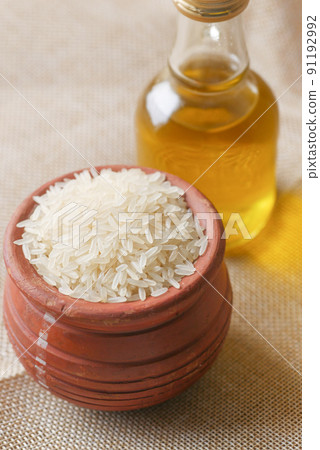 long grain rice in a bowl and bottle of oil on table long grain rice in a bowl and bottle of oil on table 91192992