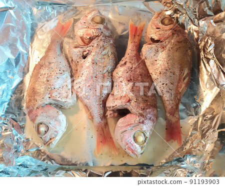 Cooking fresh fish on foil. Top view and close up. Healthy sea food. Diet meal preparation. Cooking fresh fish on foil. Top view and close up. Healthy sea food. Diet meal preparation. 91193903