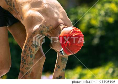 Closeup young handsome man, professional swimmer in goggles and swimming cap getting ready to swim, outdoors. Sport, power, energy, style, hobby concept. 91196496
