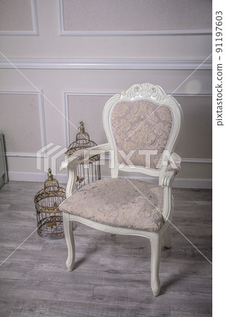 Old western style white elegant armchair with bird cage Old western style white elegant armchair with bird cage 91197603