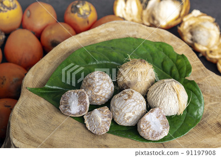 Betel nut or areca nut with betel leaf isolated on wooden background. 91197908