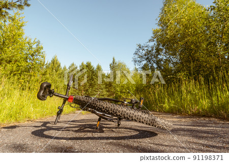 Bicycle lies on rural road 91198371