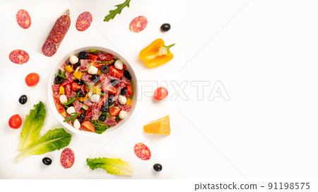 Salad with tomato, olives, bell pepper, salami, mozzarella, lettuce and arugula on white background. Top view, concept for menu or ingridient Salad with tomato, olives, bell pepper, salami, mozzarella, lettuce and arugula on white background. Top view, concept for menu or ingridient 91198575
