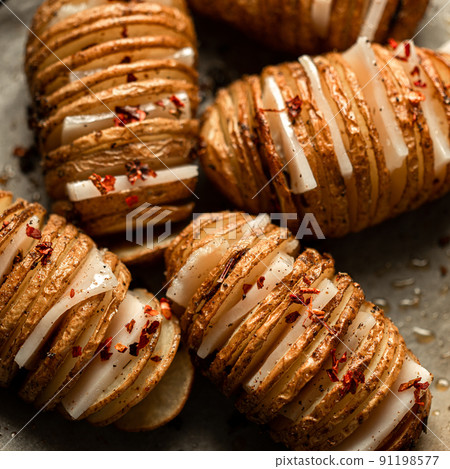 Hasselback Baked Potatoes with Fresh Herbs and pork fat, lard, tallow, garlic. National Ukrainian food. Top view. Hasselback Baked Potatoes with Fresh Herbs and pork fat, lard, tallow, garlic. National Ukrainian food. Top view. 91198577
