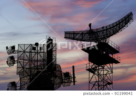 Air defense radars of military mobile anti aircraft systems, modern army industry on the background of the sunset orange sky, Russia 91199041