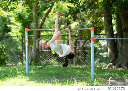 Girl playing on the horizontal bar 91199673