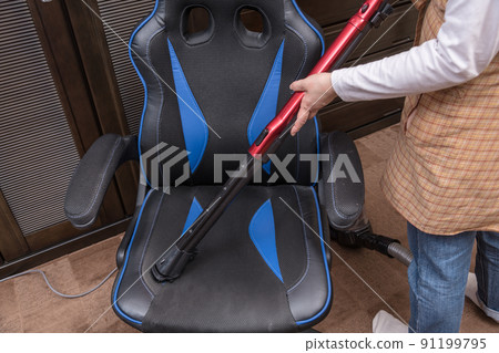 [Middle housewife cleaning a gaming chair with a cyclone cleaner] 91199795