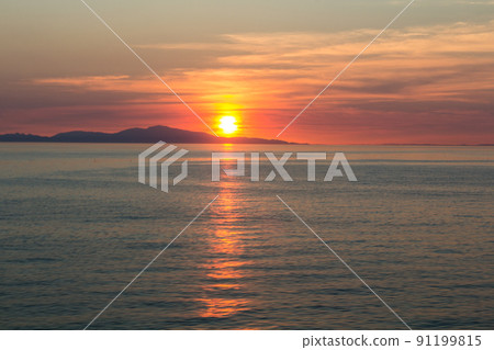 Falling sunset, reflection of the sea surface, gradual sky 91199815