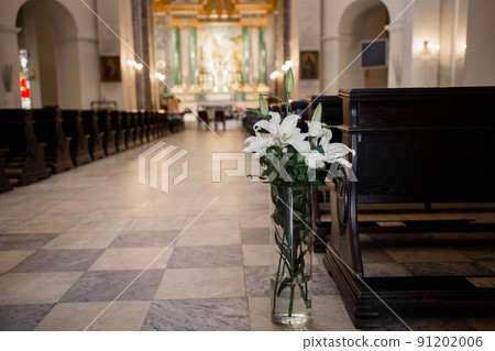 decor of flowers and a wooden bench in the Catholic Church decor of flowers and a wooden bench in the Catholic Church 91202006