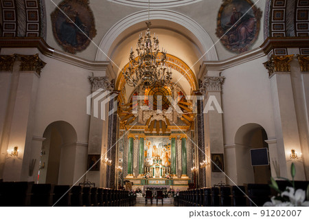 interior of a beautiful catholic church with benches icons and chandeliers 91202007