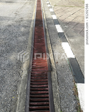 water drain or ditch on the road. Gutters drain grate, drain cover. Road drains - sewer cover. iron grate of water drain on the road in every city. Water go down to the drain on the road 91202566