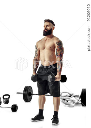 Muscular bodybuilder guy doing exercises with dumbbells over white background 91206030