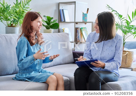 Female professional child psychologist working with preteen girl in office Female professional child psychologist working with preteen girl in office 91208356