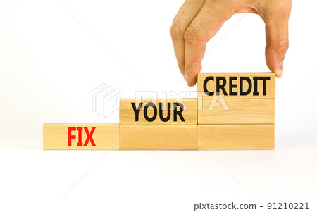 Fix your credit symbol. Concept words Fix your credit on wooden blocks on a beautiful white table white background. Businessman hand. Business, finacial and fix your credit concept. Copy space. 91210221