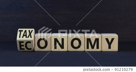 Taxonomy or economy symbol. Turned wooden cubes and change the concept word Economy to Taxonomy. Beautiful black table black background. Business ecology taxonomy or economy concept. Copy space. 91210279