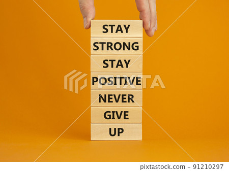 Never give up symbol. Wooden blocks with concept words Stay strong stay positive never give up. Beautiful orange background. Copy space. Businessman hand. Motivational business never give up concept. Never give up symbol. Wooden blocks with concept words Stay strong stay positive never give up. Beautiful orange background. Copy space. Businessman hand. Motivational business never give up concept. 91210297