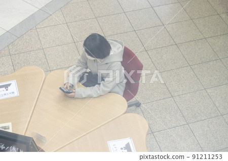 鳥瞰坐在公共設施椅子上的婦女 鳥瞰坐在公共設施椅子上的婦女 91211253