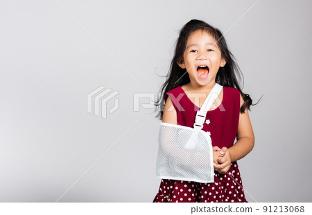 Little cute kid girl 3-4 years old hand bone broken from accident with arm splint in studio shot isolated Little cute kid girl 3-4 years old hand bone broken from accident with arm splint in studio shot isolated 91213068
