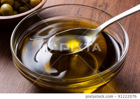 用勺子舀橄欖油 用勺子舀橄欖油 91222076