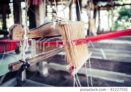 Thai and Asian Style Vintage textile thread wooden machine to make traditional clothing and fabric pattern weaving. 91227502