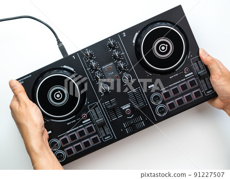 Hand holding a DJ controller Deck set isolated on white background. 91227507